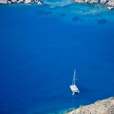 Lone sailing boat in southern crete seen from high up in the highlands